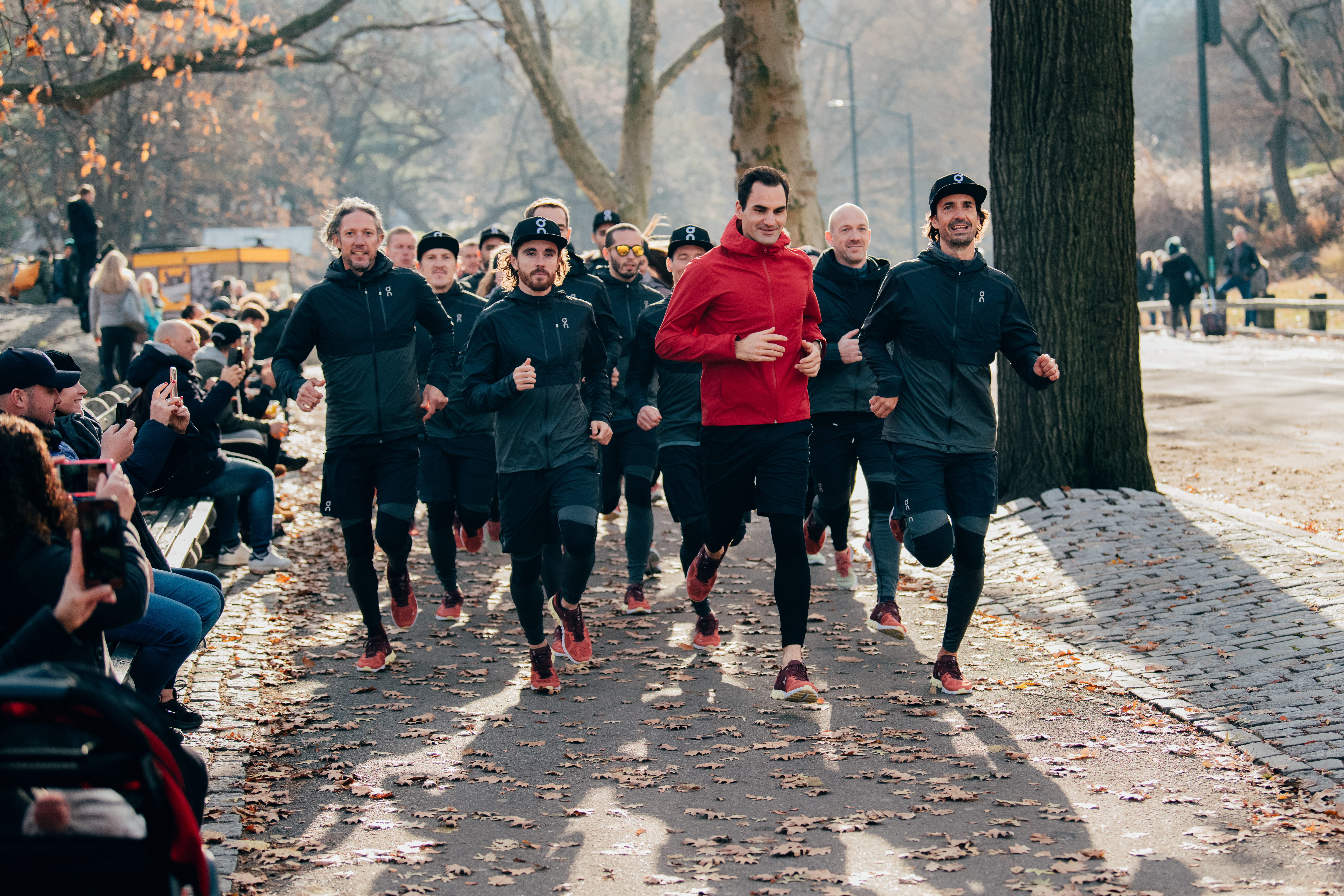 Roger Federer in a crowd of runners trying out On trainers in a New York City park.