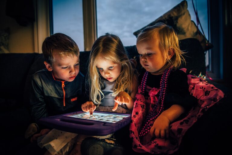 Three children starring at a screen