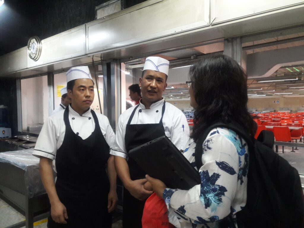 Woman interviewing two cooks